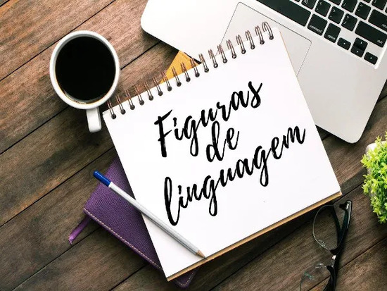 a frase "figuras de linguagem" está escrita em letra manuscrita sob uma folha branca de um caderno de espiral sem linhas e uma caneta com tampa azul está à esquerda da imagem