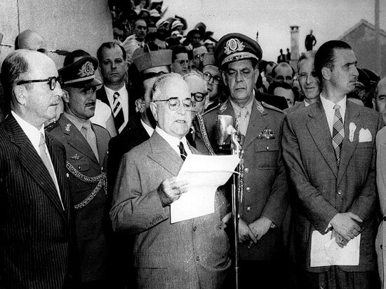O ex-presidente do Brasil, Getúlio Vargas, discursa, entre apoiadores homens. Foto está em preto e branco